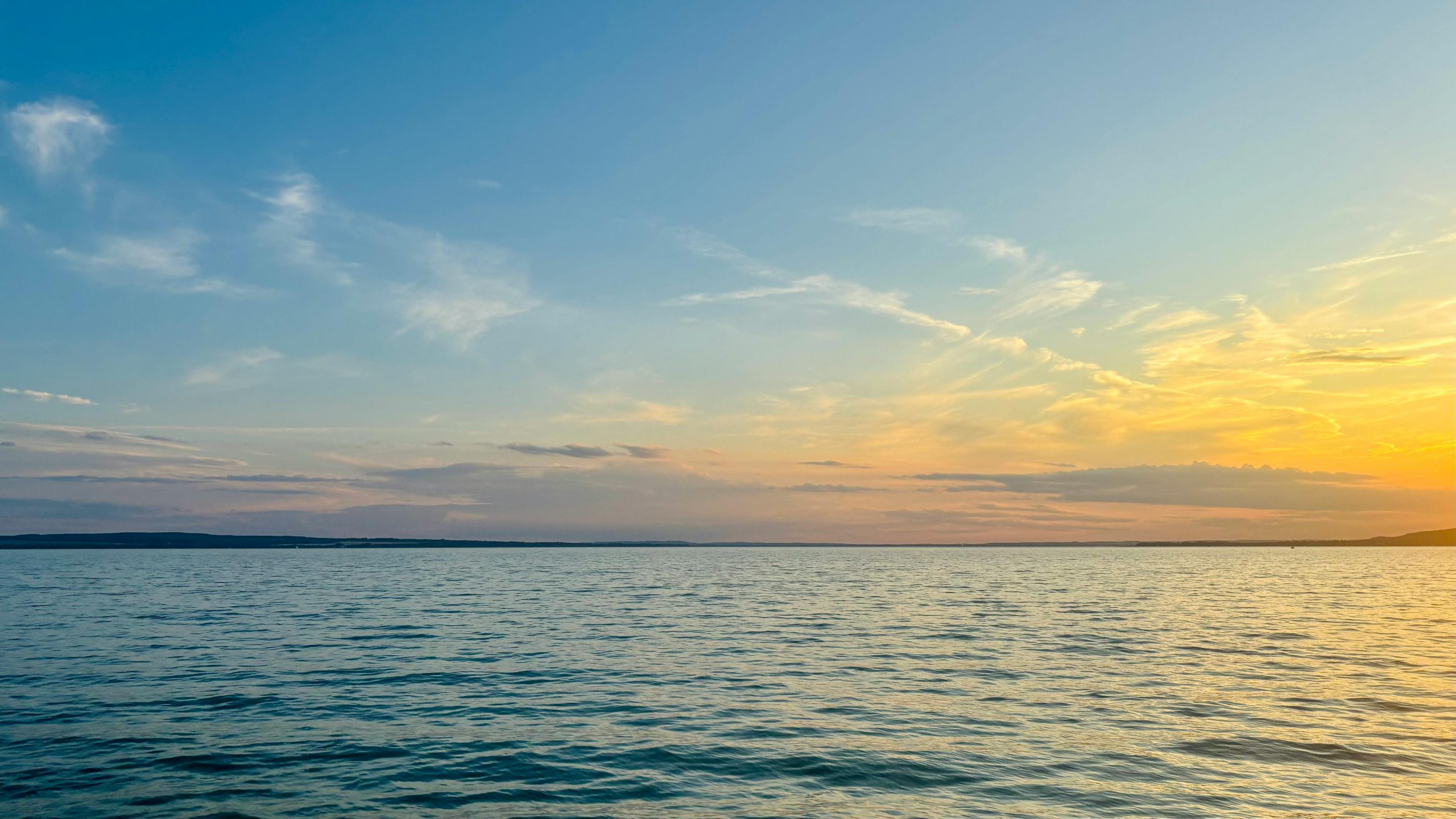 Beautiful sunset over Lake Balaton in Hungary, capturing serene water and colorful skies.